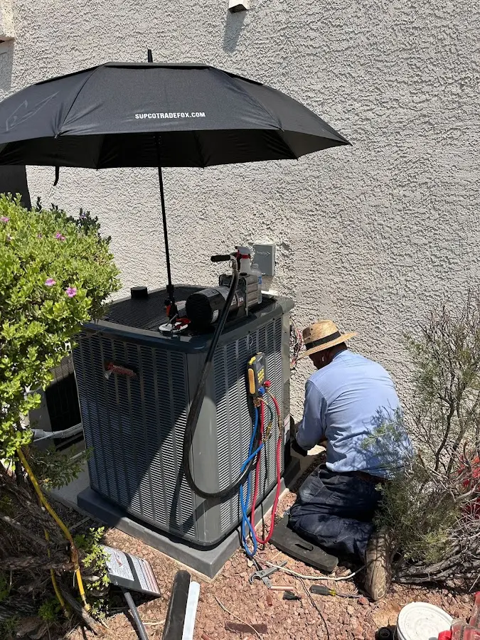 HVAC technician performing outdoor AC maintenance in Carlinville