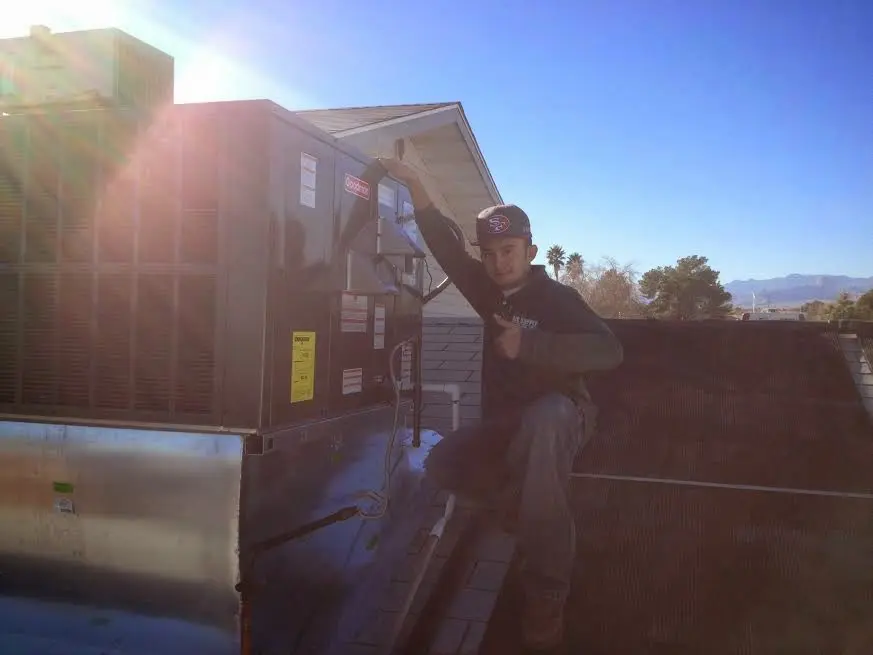 HVAC technician performing Heat Pump Repair on a rooftop unit in Carlinville